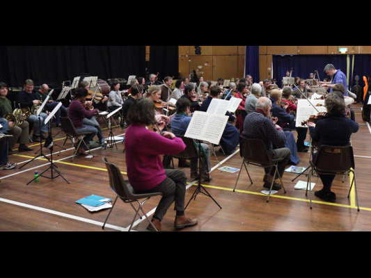 Will Orr rehearsing the Brahms, viewed from behind the violins.